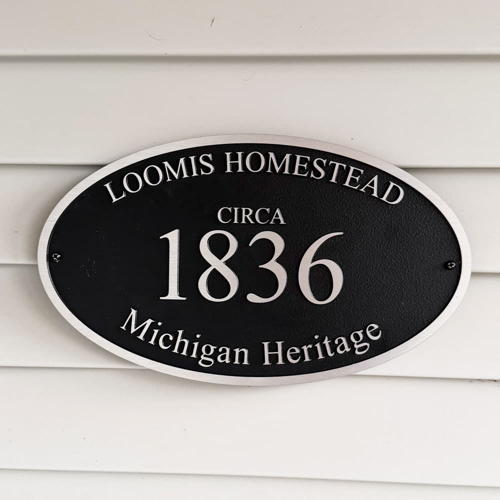 Plaque reading "Loomis Homestead, Circa 1836, Michigan Heritage."