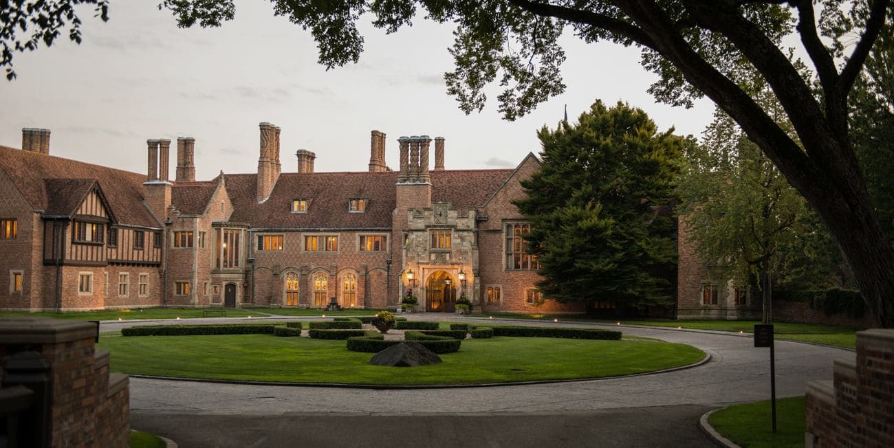 A grand historic mansion surrounded by well-manicured lawns and trees. A grand historic mansion surrounded by well-manicured lawns and trees.