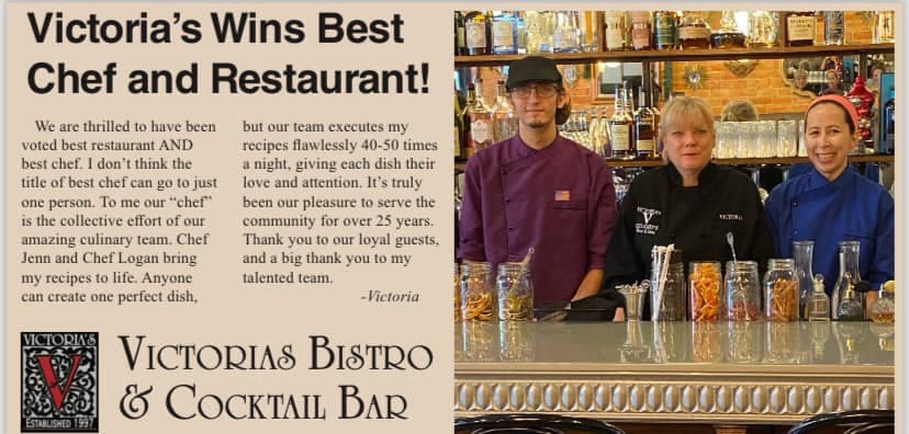 Three chefs stand behind a bar at Victoria's Bistro & Cocktail Bar, celebrating their award for best chef and restaurant.