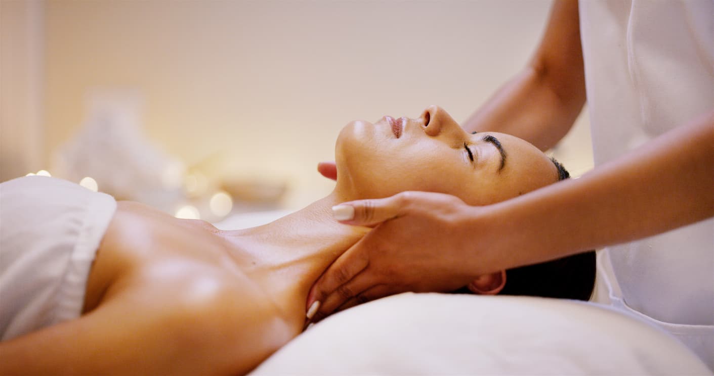 A woman receives a neck massage in a tranquil setting. A woman receives a neck massage in a tranquil setting.
