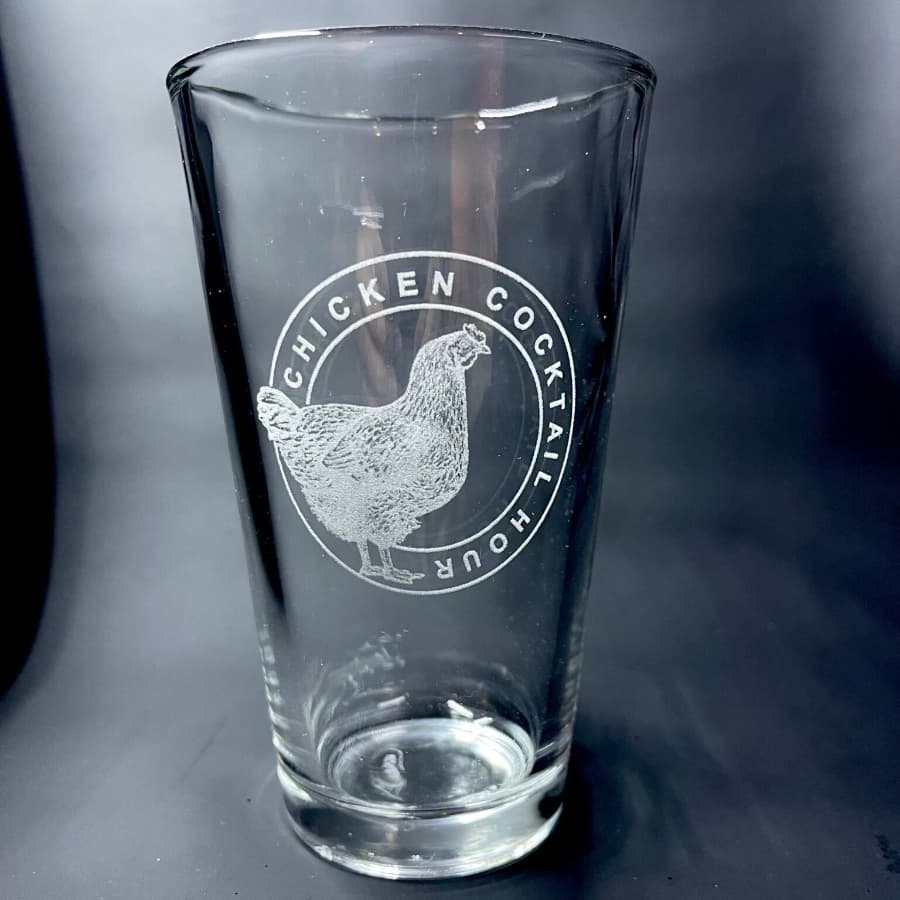 A clear glass featuring an etched chicken and the text "CHICKEN COCKTAIL HOUR."